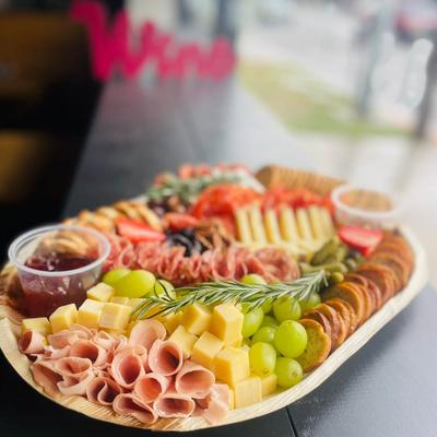 Charcuterie board with meats, cheeses, and fruits.
