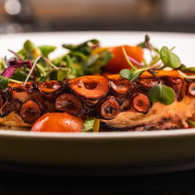 Char - Grilled Octopus with tomatoes, olives, capers and celeriac puree.