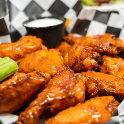 Sauced wings with celery sticks and dipping sauce.