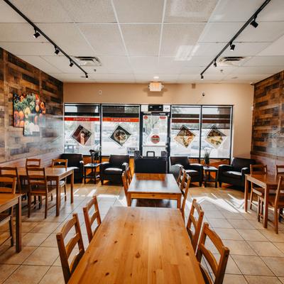 Diner table in front, tables and chairs around, view to entrance.