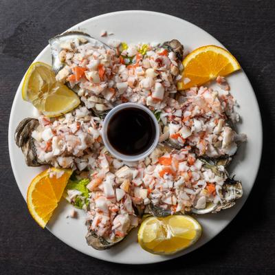 Oysters with Ceviche served with citrus wedges and sauce, overhead view.