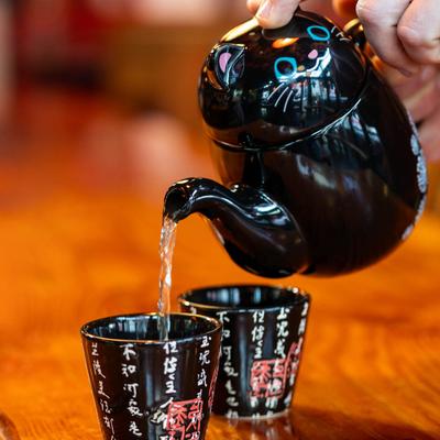 A hand pouring tea into cups.