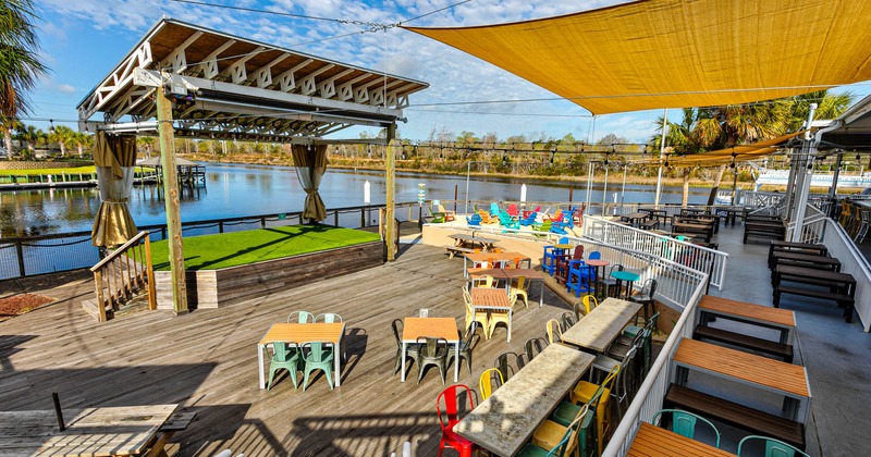 Exterior, stage, wooden flooring, partially covered seating area, river view