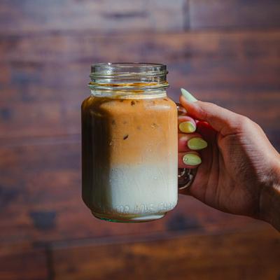 A hand holding the iced latte.