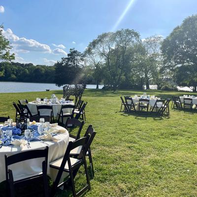 Outdoor event setup on a lakeside lawn.