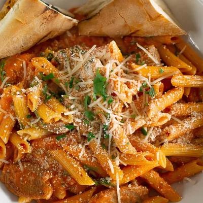 Penne pasta, with tomato cream sauce, Italian sausage, and baby arugula.
