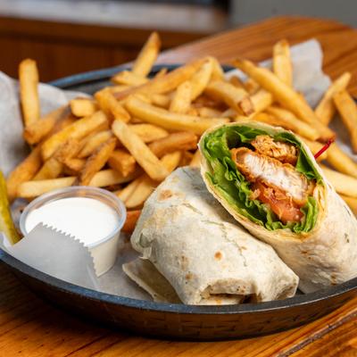 Buffalo chicken wrap served with creamy white dip and french fries.