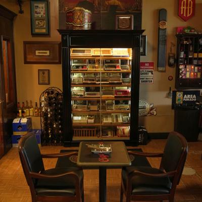 Cigar shop featuring a glass display case and seating.