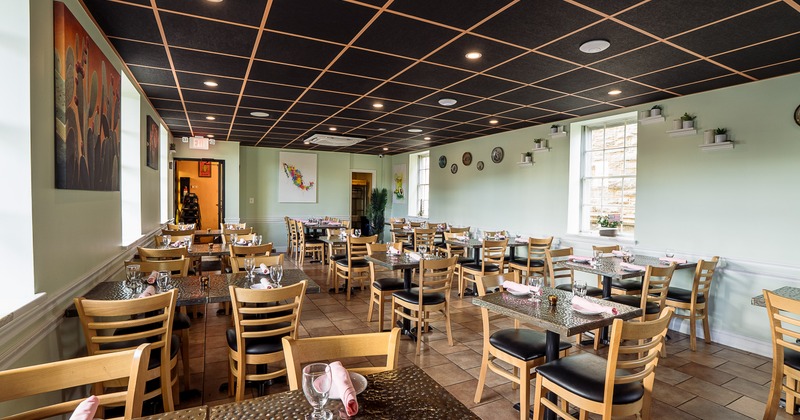 Interior of spacious and cozy dining area with set dining tables