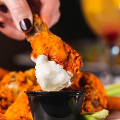 Dipping a chicken wing, closeup