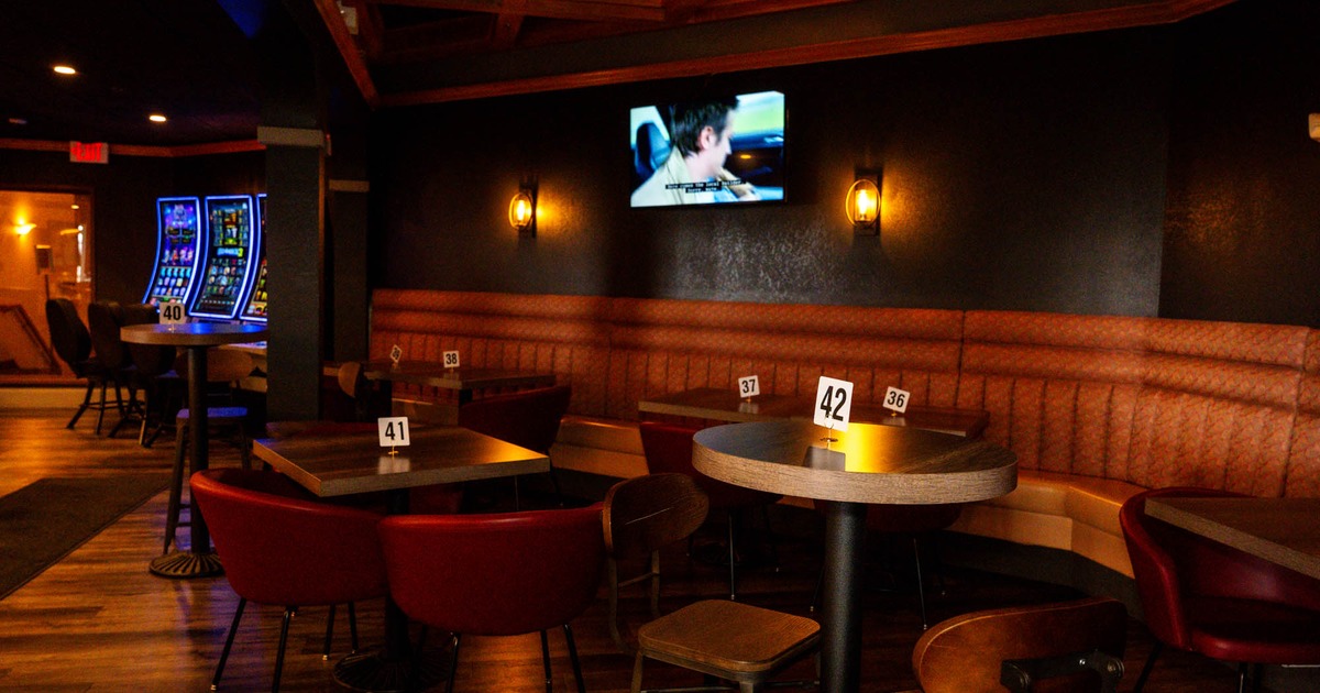 Interior, corner dining area, long banquette bench with wooden top tables and chairs