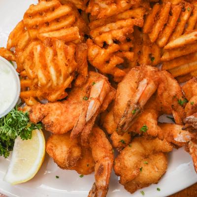 Fried shrimp, sauce, and waffle fries.
