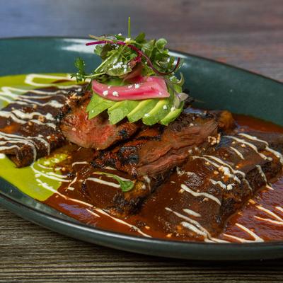 Skirt steak and enmoladas in Mole, red, and green sauces.