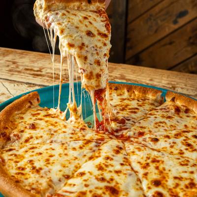 A slice of cheese pizza being lifted from the pie.