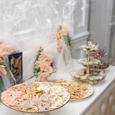 Dessert table decorated with soft pink floral accents.
