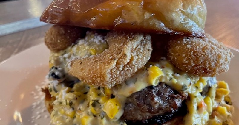 Burger with onion rings, and corn salsa