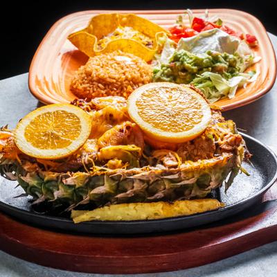 Grilled pineapple filled with grilled chicken.