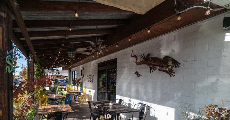 Patio with tables and chairs decorated with plants