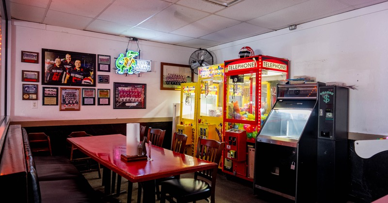 An arcade room with claw machines and seating area