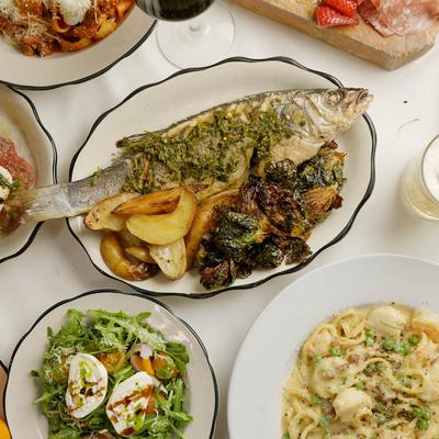 Assorted dishes including roasted branzino, burrata arugula salad, and a pasta dish.