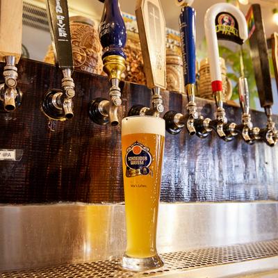 A glass of Schneider Weisse beer on tap.