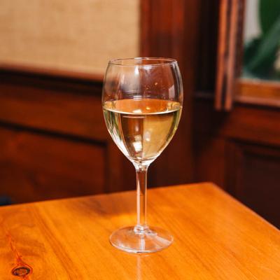 Interior, a glass of chardonnay on a table.