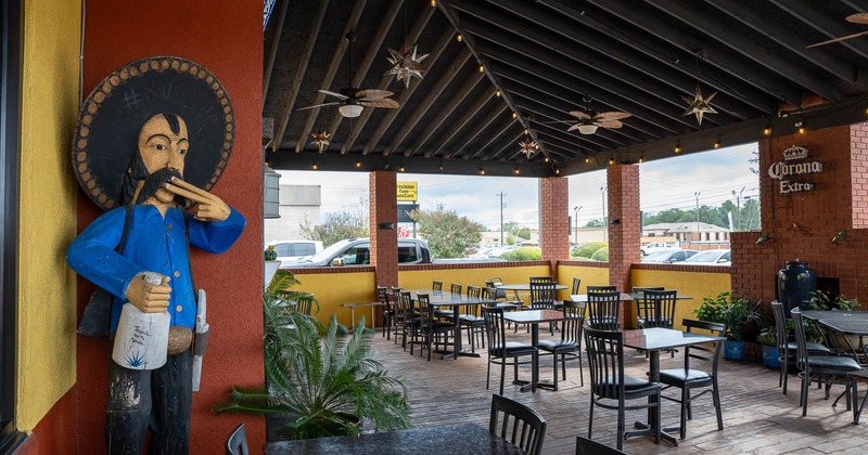 Outdoor patio with tables, chairs, and plants