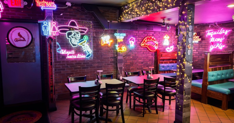 Interior - red brick walls, neon signs, string lights, tables, chairs, turquoise leather booths