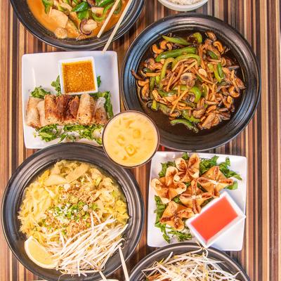Colorful Thai dishes arranged on a striped table.