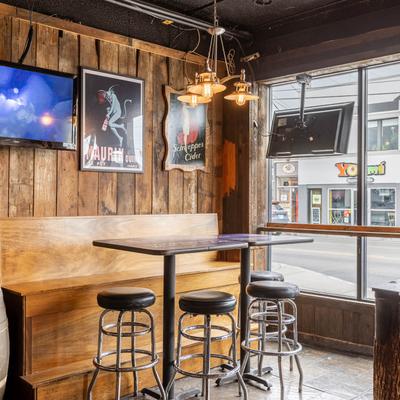A room with seating area, wooden walls and wall picture.
