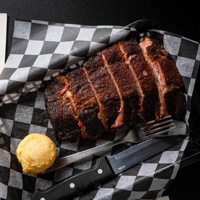 Half rack of ribs with a corn muffin, overhead view.