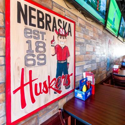 Dining table and a mural of Nebraska Huskers football team.