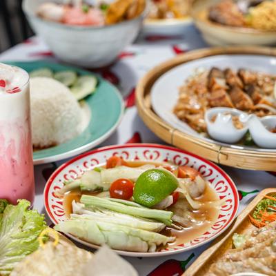 A vibrant spread of traditional Thai dishes, featuring spicy green papaya salad.