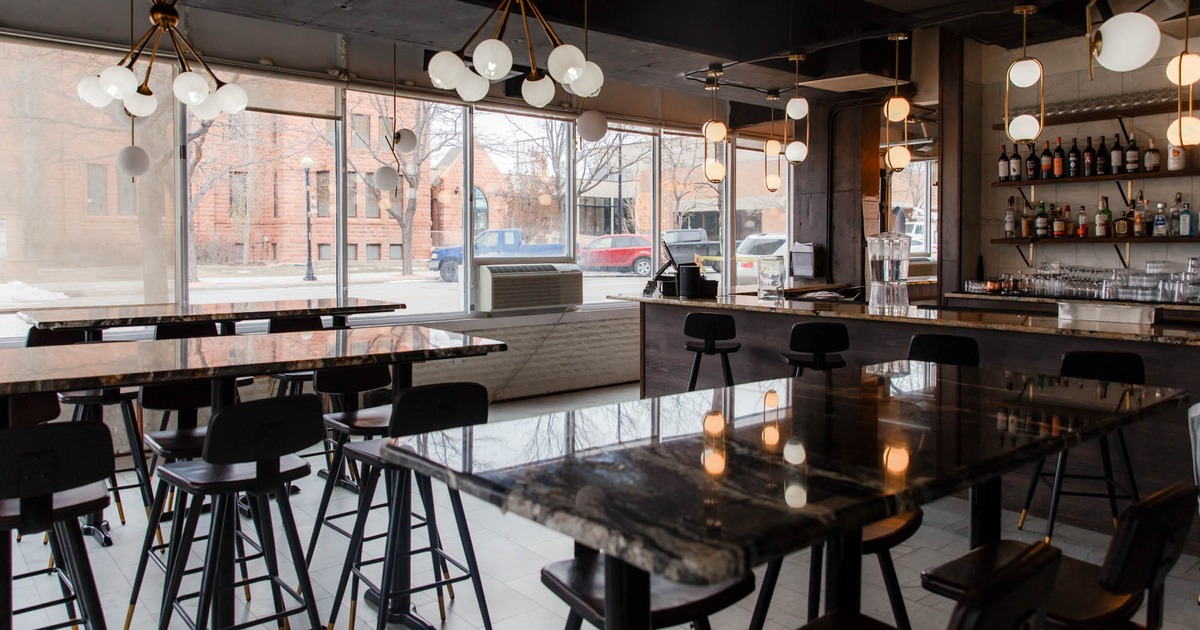 Seating area with barstools, large windows overlooking the street