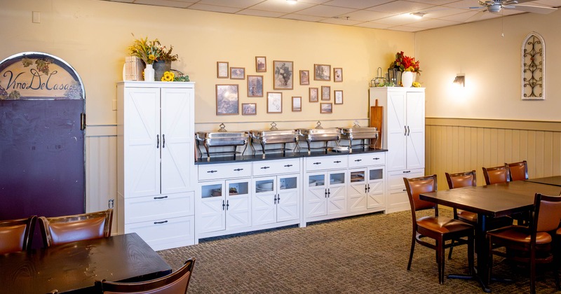 Interior with white cabinets and serving dishes; framed photos on the wall