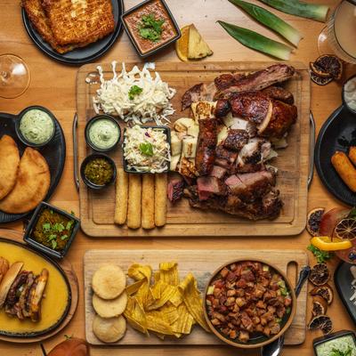 Assorted grilled meats and sides covering a wooden table.