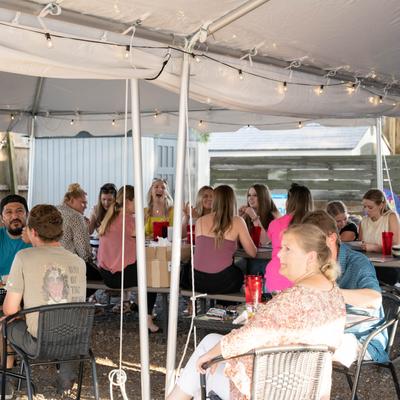 Exterior, guests dining in the patio area.