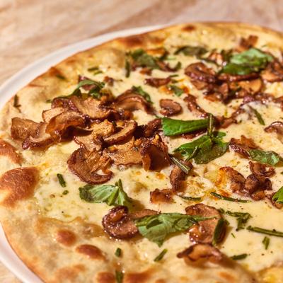 Pizza with cheese, basil, and mushrooms.