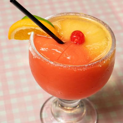 Frozen margarita cocktail with cherry and orange slice garnish.