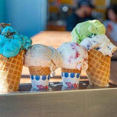 Waffle cones filled with scoops of assorted ice cream.