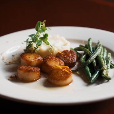 Seared scallops, served with mashed potatoes and green beans.