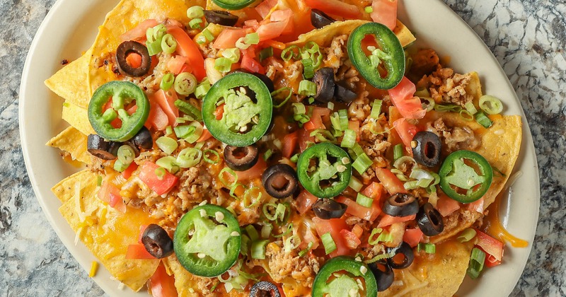 nachos with cheese, olives, onions, tomatoes, and jalepenos