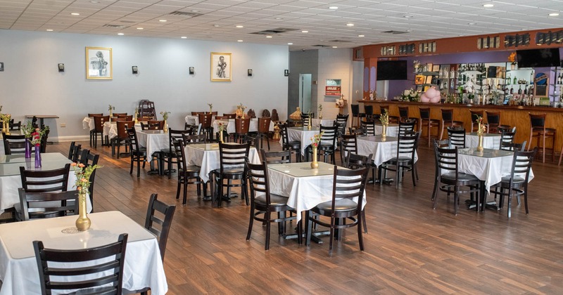 Interior, dining tables decorated with flowers in vases, bar
