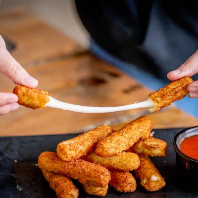 Hands stretching a mozzarella stick.