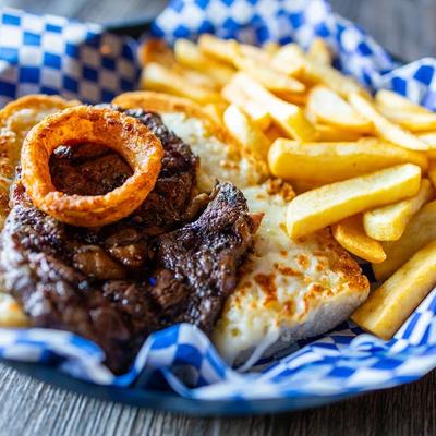 Grilled Angus beef ribeye, served with cheese garlic bread, fries, and an onion ring.