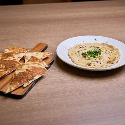 Hummus and pita bread on the side.