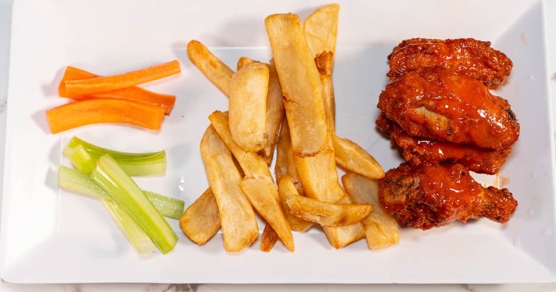 Buffalo chicken wings, with celery, carrots, and fries