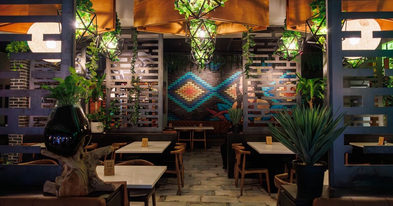 Interior, dining area, marble top tables with chairs, lavish plant decoration