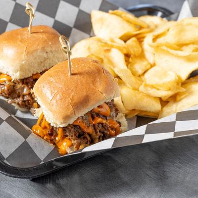 Philly steak and cheese sliders, served with potato chips.