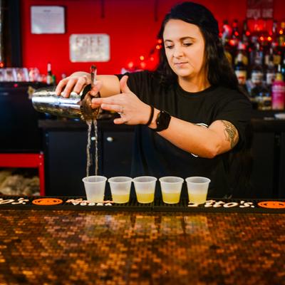 Bartender pouring cocktail shots.